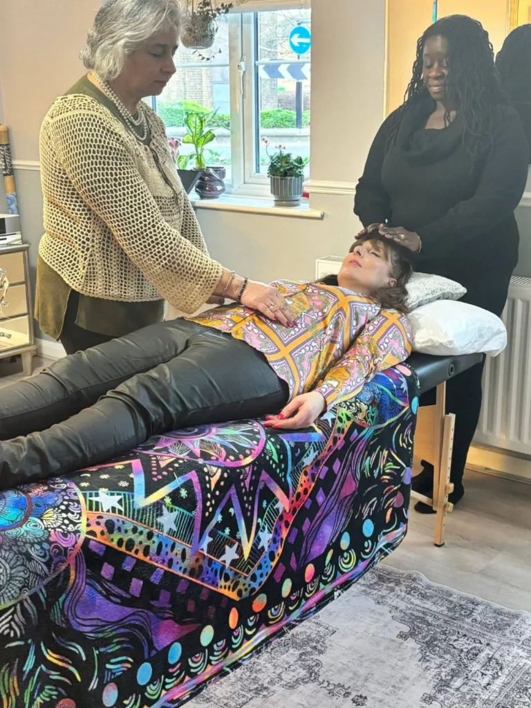 hands-on Reiki training in Enfield with students practising techniques on teacher